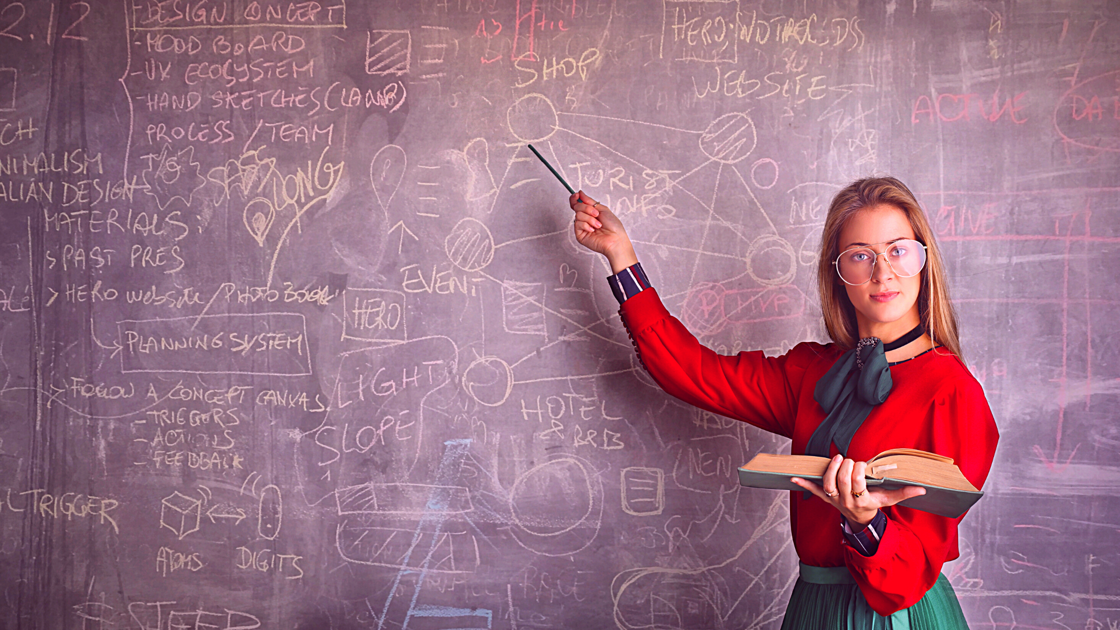 Woman teaching, pointing to blackboard